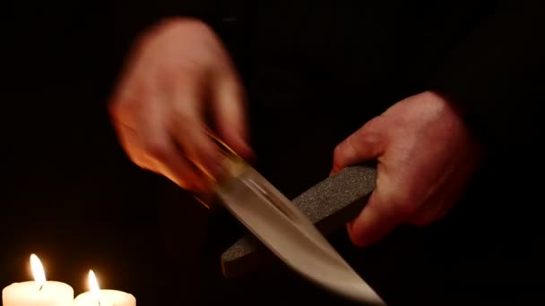 Изолированные руки затачивают боевой нож — стоковое видео