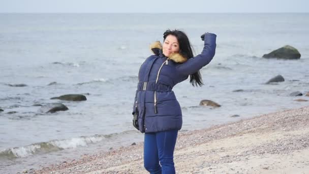 Mujer bonita en tela de invierno posando como pussycat en línea de mar cámara lenta — Vídeos de Stock