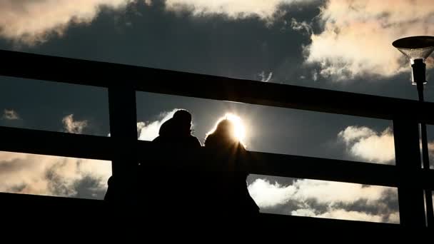 Persone silhouette si muove sul ponte rallentatore con belle nuvole e sole tremolante — Video Stock