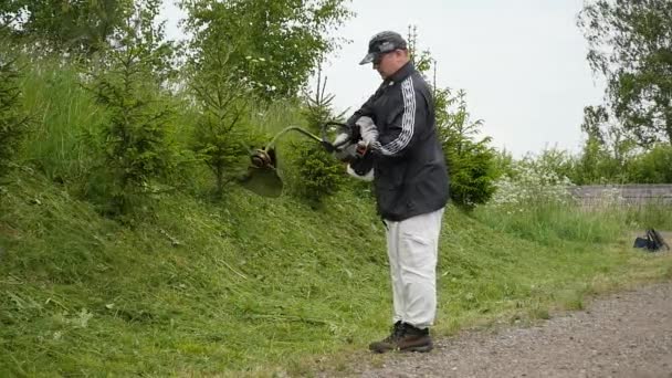 L'homme commence à tondre l'herbe avec tondeuse au ralenti — Video