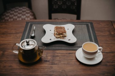 Tabakta bir parça tiramisu. Tatlılı çay partisi. Kremalı bir pasta. Tablo ayarı