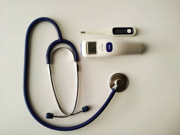 Blå medicinsk stetoskop, termometer på vit bakgrund — Stockfoto