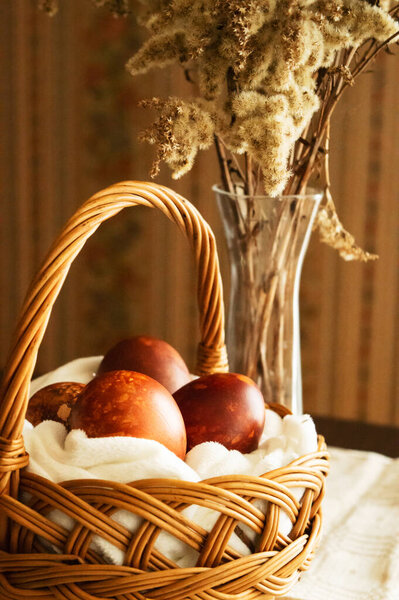 Easter eggs painted with natural dyes in a wicker basket. Easter background