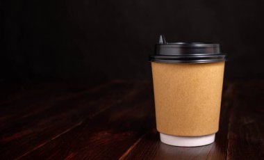 Kahveler için kağıt bardak, tahta arka planda.