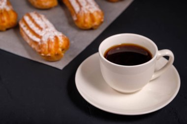 Beyaz fincanda sade kahve ve koyu arkaplanda krema.