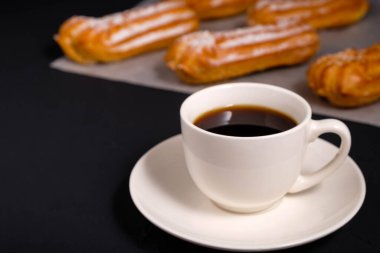 Beyaz fincanda sade kahve ve koyu arkaplanda krema.