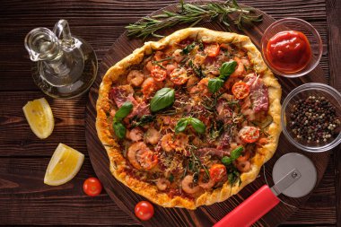 Karidesli, domatesli, peynirli ve otlu pizza.