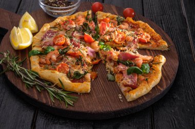 Karidesli, domatesli, peynirli ve otlu pizza.