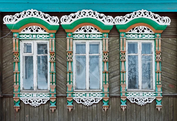 A Rússia. Suzdal. Três janelas com molduras de madeira esculpidas . — Fotografia de Stock