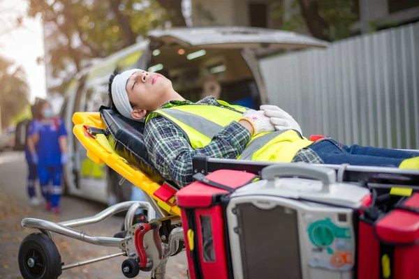 Yaralıları ambulansla hastaneye götürmek için sedyede yatan hasta baygın ve kafası kırık bir erkek hasta..