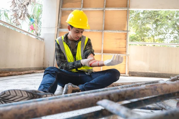 Physical injury at work of construction worker. Injury bleeding from work accident in pile of scaffolding steel falling down to impinge the arm.