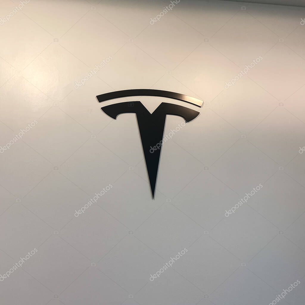 Orlando, FL/USA-2/17/20:  The Tesla logo on the wall at a Tesla retail store.  Tesla is an electric automobile company owned by Elon Musk.