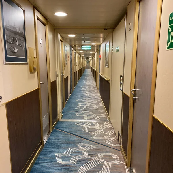 游轮上的一条走廊 有蓝色几何图案的地毯和乳白色的墙壁 — 图库照片