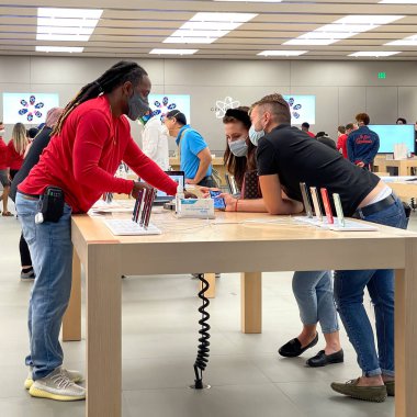 Orlando, FL USA - 20 Kasım 2020: Bir Apple mağazasında satılık en son Apple iPhone 12 modellerine bakan bir satıcı ve müşteri.
