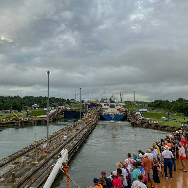 Панама - 11 / 6 / 19: Круизный корабль с пассажирами на носу, наблюдающими за входом корабля в Панамский канал.
