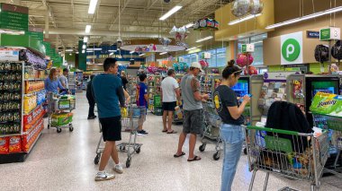 Orlando, FL USA - 12 Mart 2020: Halkın paniklemesi ve stoklama ürünleri nedeniyle bir Publix marketinde yiyecek ve dezenfektanla dolu arabalarla tipik bakkal kuyrukları
