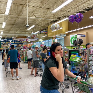 Orlando, FL USA - 12 Mart 2020: Halkın paniklemesi ve stoklama ürünleri nedeniyle bir Publix marketinde yiyecek ve dezenfektanla dolu arabalarla tipik bakkal kuyrukları