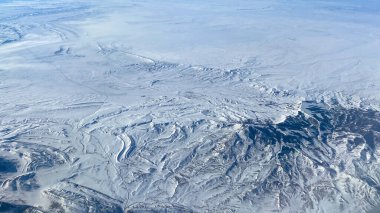 Dağlardan, kardan, bulutlardan ve parlak mavi gökyüzünden bir hava manzarası.