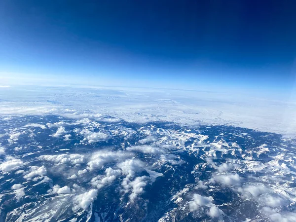 Widok Okna Samolotu Gór Śniegu Chmur Jasnego Błękitnego Nieba — Zdjęcie stockowe