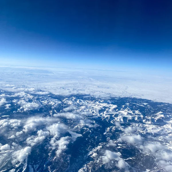 Widok Okna Samolotu Gór Śniegu Chmur Jasnego Błękitnego Nieba — Zdjęcie stockowe