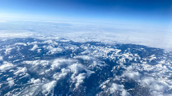 Uma Vista Aérea Uma Janela Avião Montanhas Neve Nuvens Céus — Fotografia de Stock