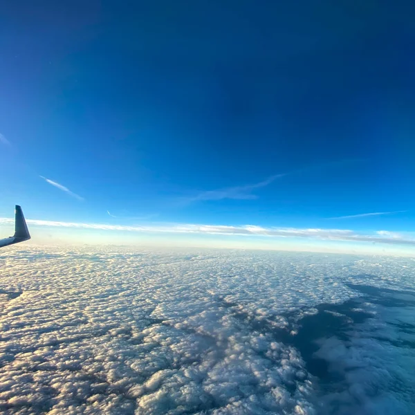 从天空明亮的云彩的飞机窗上俯瞰的天空 — 图库照片