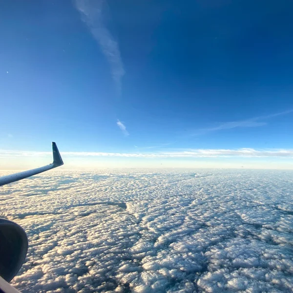 从天空明亮的云彩的飞机窗上俯瞰的天空 — 图库照片