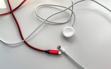 Usb c, saat ve cep telefonu kablosu beyaz arka planda şarj ediliyor.
