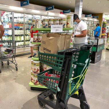 Orlando, FL USA - 24 Ocak 2021: Amazon Prime Fresh çalışanları Whole Foods marketinden alışveriş yaparak insanların evlerine götürmeleri için yiyecek seçiyorlar..