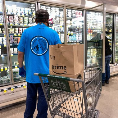 Orlando, FL USA - 24 Ocak 2021: Amazon Prime Fresh çalışanları Whole Foods marketinden alışveriş yaparak insanların evlerine götürmeleri için yiyecek seçiyorlar..