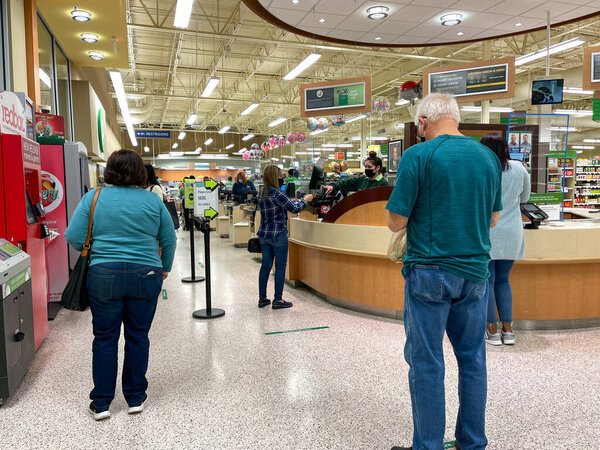 Orlando,FL USA - January 15, 2021:  People waiting in line to purchase lottery tickets at a Publix grocery store in Orlando, Florida.