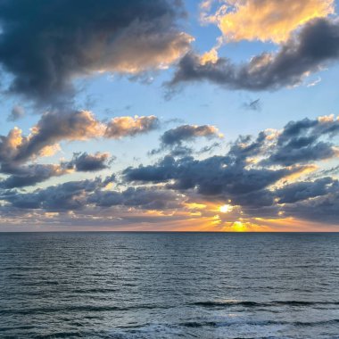 Atlantik Okyanusu üzerinde mavi gökyüzü ve beyaz bulutlarla güzel bir gün doğumu..