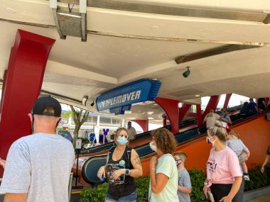 Orlando, FL USA - 2 Mayıs 2021 - İnsanlar Orlando, Florida 'daki Disney World Magic Kingdom' da Peoplemover 'a binmek için kuyrukta bekliyorlar.