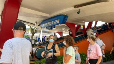 Orlando, FL USA - 2 Mayıs 2021 - İnsanlar Orlando, Florida 'daki Disney World Magic Kingdom' da Peoplemover 'a binmek için kuyrukta bekliyorlar.