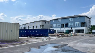 Orlando, FL USA - 12 Nisan 2021 Laureate Park Nona Orlando, Florida 'da yapım aşamasında olan yeni bir şehir evinin bahçesindeki çöp bidonu.