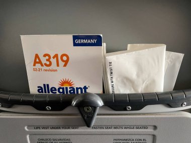 Orlando, FL USA- 13 Mayıs 2021: Arka koltukta bulunan uçağın güvenlik bilgilerini içeren dev bir uçak broşürü.