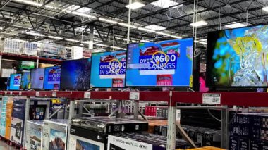 Orlando, FL USA - 23 Ocak 2020: Tüketiciler tarafından satın alınmaya hazır çeşitli televizyonlarla bir Sams Club toptan satış mağazasının TV koridorundan sola dönmek.