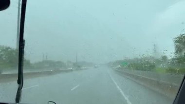 Yağmurlu bir günde silecekleri sileceklerle bir şehirde araba sürmek ön camı sudan uzak tutmaya çalışmak.