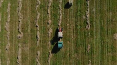 Tarım makineleri rulolarda ve büyük balyalarda kuru saman topluyor..