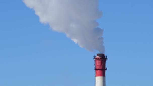 Chimney of power plant on blue sky white vapor from red tube. — Stock Video