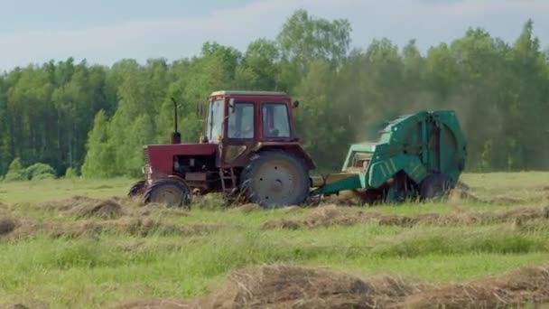 Landbouwmachines verzamelen droog stro op rollen en ronde grote balen. — Stockvideo