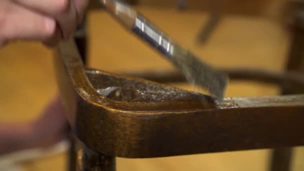 Aplicación de pegamento con un pincel sobre una silla lacada en madera vieja — Vídeo de stock