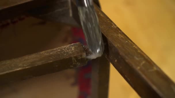 Ragasztó alkalmazása ecsettel egy régi fából készült lakkozott széken — Stock videók