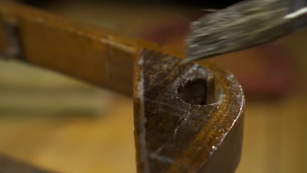 Aplicando cola com uma escova em uma cadeira laqueada de madeira velha — Vídeo de Stock