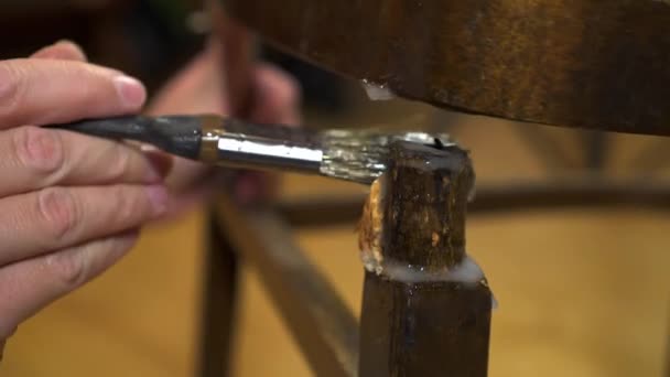 Applying glue with a brush on an old wood lacquered chair — Stock Video