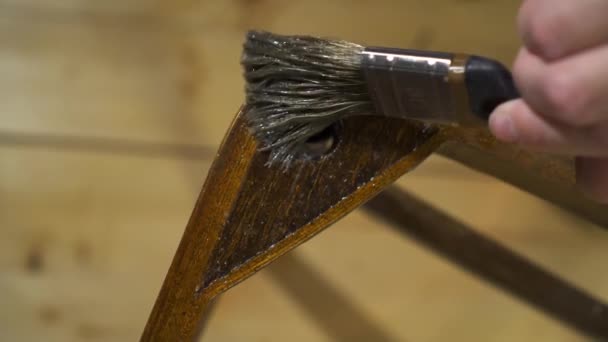 Aplicando cola com uma escova em uma cadeira laqueada de madeira velha — Vídeo de Stock