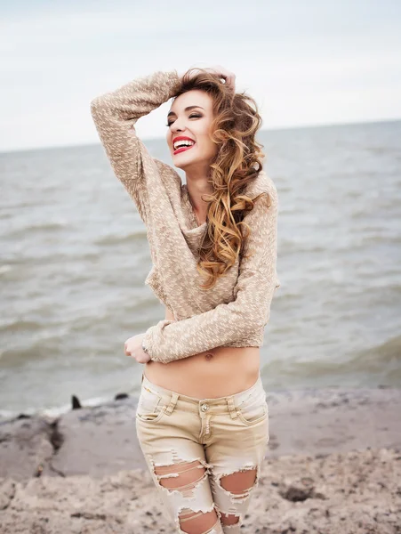 Молодая счастливая смеющаяся женщина на фоне моря — стоковое фото