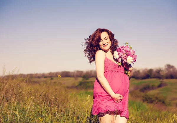 Jovem feliz mulher grávida relaxando e desfrutando da vida na natureza. — Fotografia de Stock