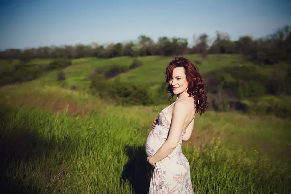 Jovem feliz mulher grávida relaxando e desfrutando da vida na natureza. — Fotografia de Stock