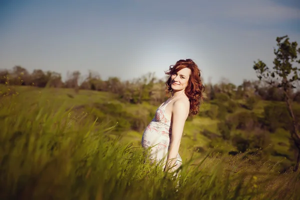 Jovem feliz mulher grávida relaxando e desfrutando da vida na natureza. — Fotografia de Stock